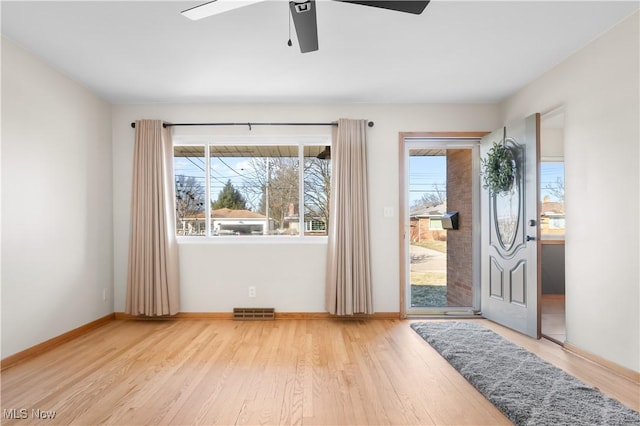 entryway with visible vents, baseboards, wood finished floors, and a ceiling fan