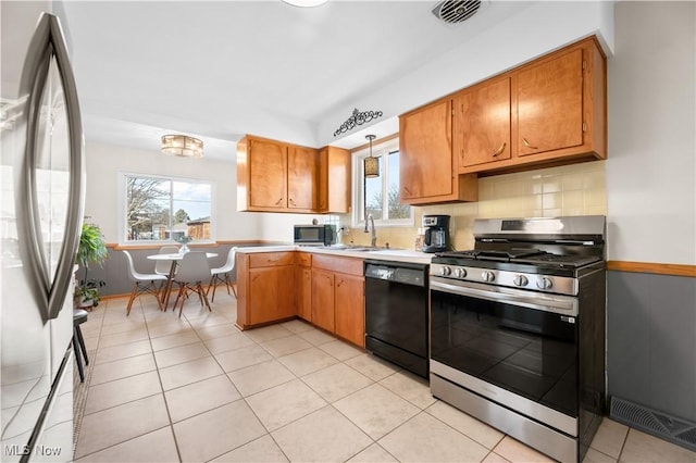 kitchen featuring visible vents, a sink, tasteful backsplash, stainless steel appliances, and light countertops