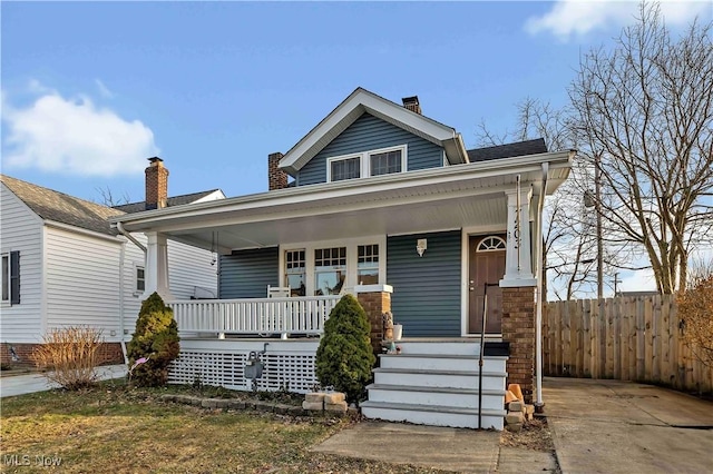 view of front of property with covered porch and fence