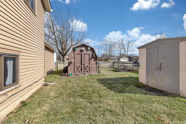 view of yard featuring a storage shed, a fenced backyard, a residential view, and an outdoor structure