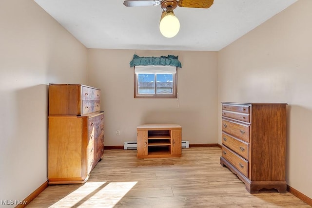 interior space with a baseboard heating unit, baseboards, and light wood finished floors