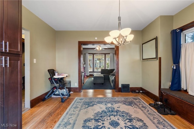 entryway featuring light wood-style flooring, visible vents, a chandelier, and baseboards