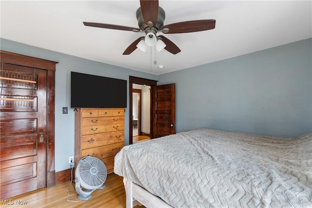 bedroom featuring light wood finished floors, a ceiling fan, and baseboards