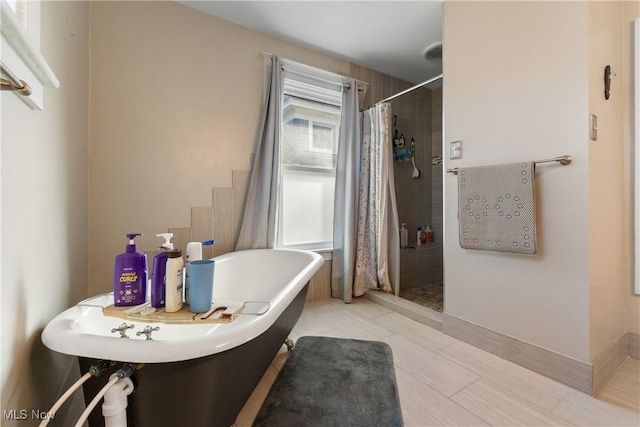 bathroom featuring a stall shower and a soaking tub