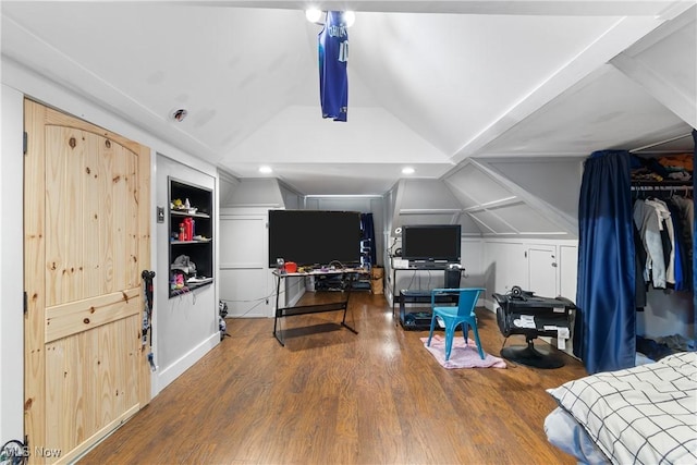 bedroom with vaulted ceiling and wood finished floors