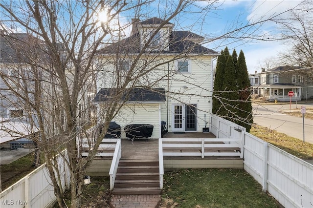 rear view of property with a fenced backyard and a wooden deck