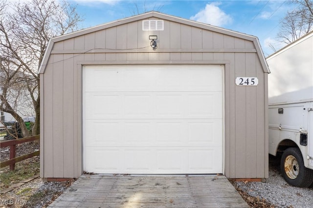 garage with driveway and fence