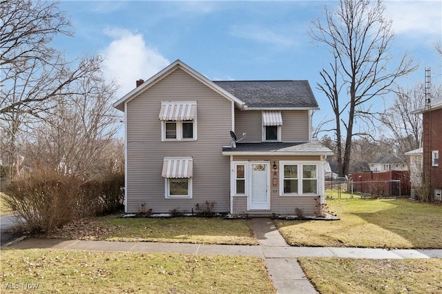 traditional home with a front yard and fence