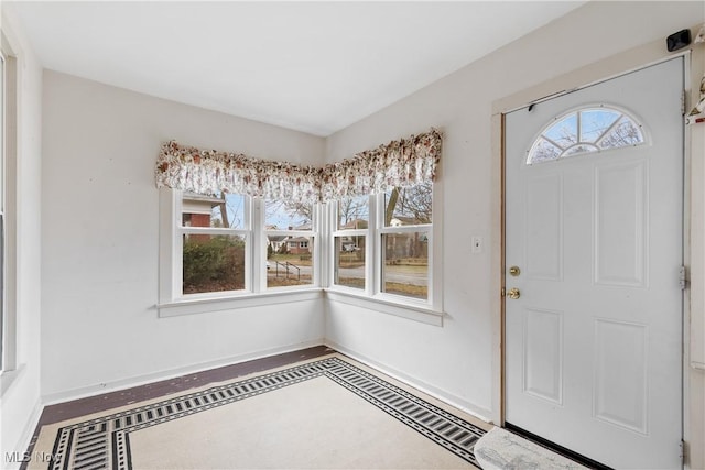 entrance foyer featuring plenty of natural light and baseboards