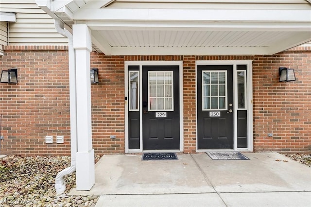 view of exterior entry featuring brick siding