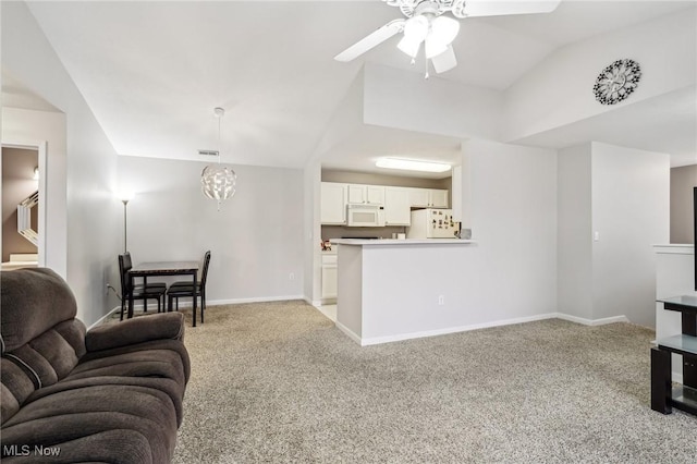 living area with light colored carpet, vaulted ceiling, visible vents, and baseboards