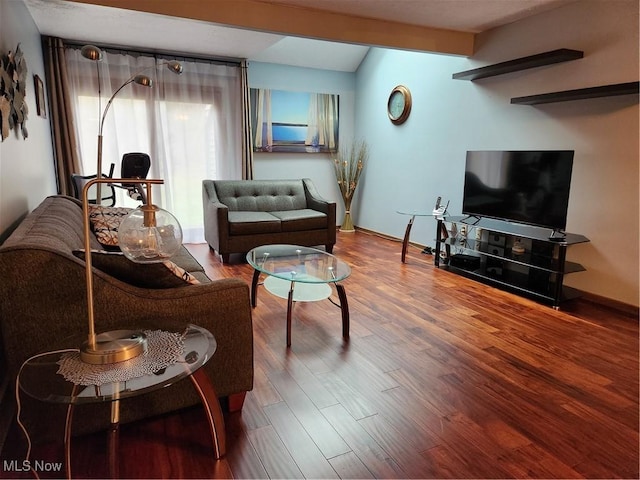 living room with lofted ceiling with beams, baseboards, and wood finished floors