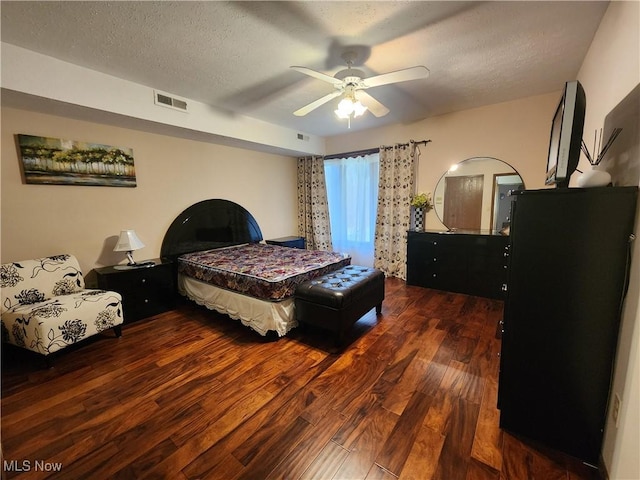 bedroom with visible vents, ceiling fan, a textured ceiling, and wood finished floors