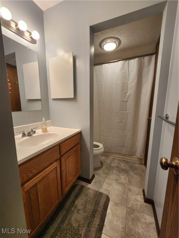 bathroom with toilet, vanity, a shower with curtain, baseboards, and tile patterned floors