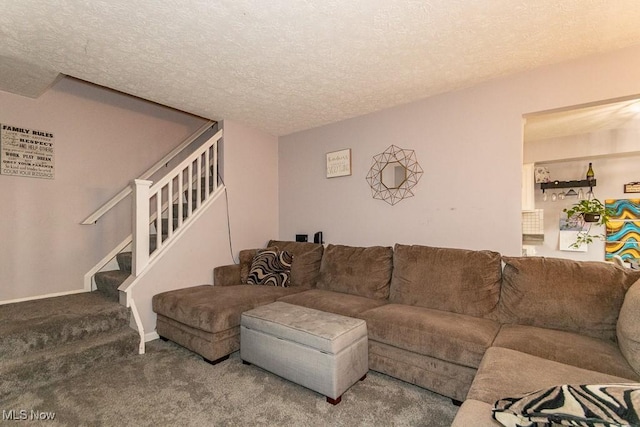 carpeted living room featuring stairs, a textured ceiling, and baseboards