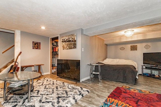 interior space featuring a textured ceiling, stairs, baseboards, and wood finished floors