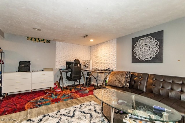 office space with a textured ceiling, wood finished floors, and visible vents