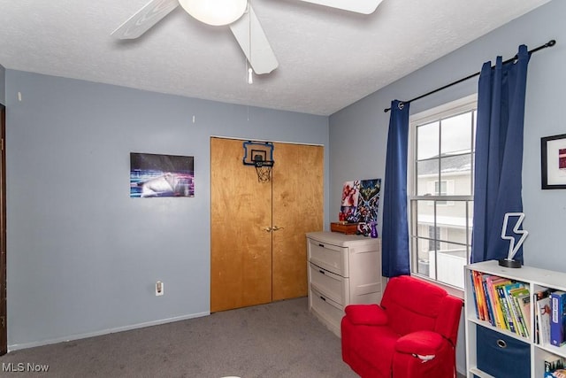 sitting room with carpet, ceiling fan, a textured ceiling, and baseboards