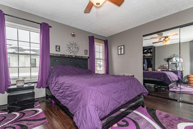 bedroom with a textured ceiling, ceiling fan, a closet, and wood finished floors