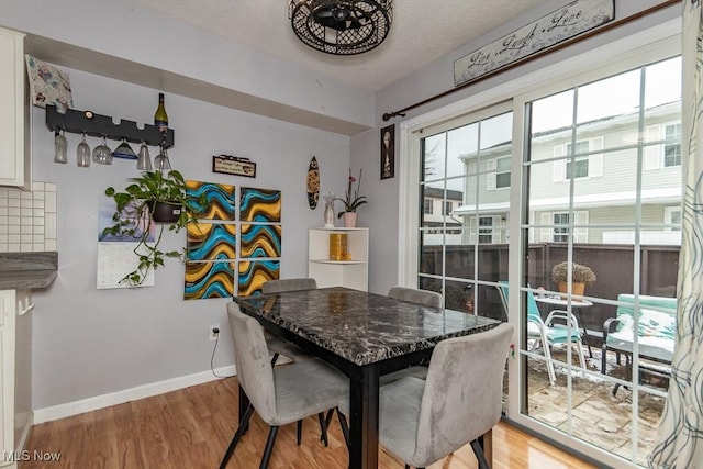 dining space with baseboards and light wood finished floors