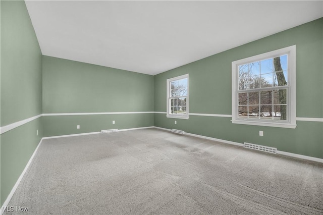 unfurnished room featuring baseboards, visible vents, and carpet flooring