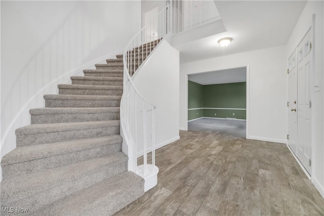 stairway featuring baseboards and wood finished floors