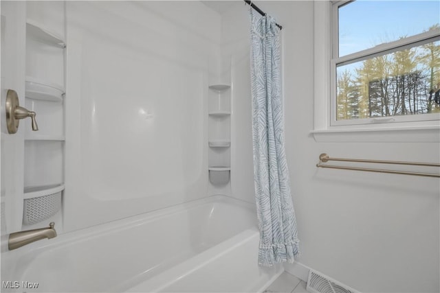 bathroom featuring baseboards and shower / tub combo with curtain