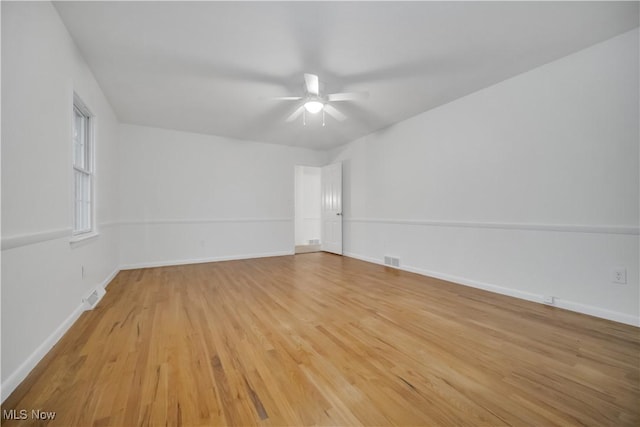 unfurnished room featuring light wood-type flooring, visible vents, and baseboards