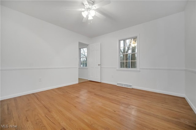 unfurnished room featuring baseboards, visible vents, ceiling fan, and light wood finished floors