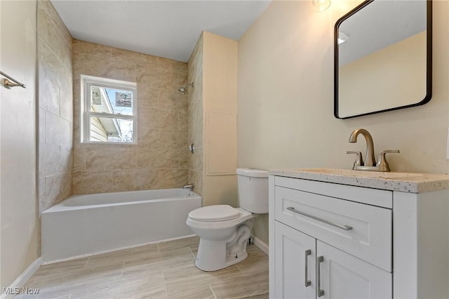 bathroom with baseboards, bathing tub / shower combination, toilet, and vanity