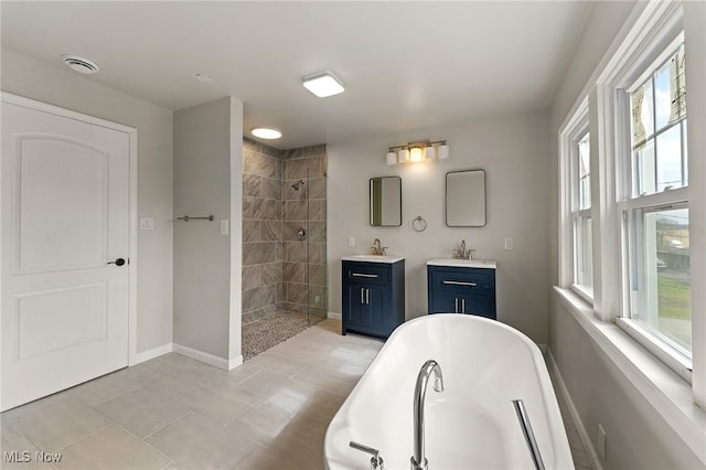 full bathroom with a freestanding tub, a sink, two vanities, visible vents, and tiled shower