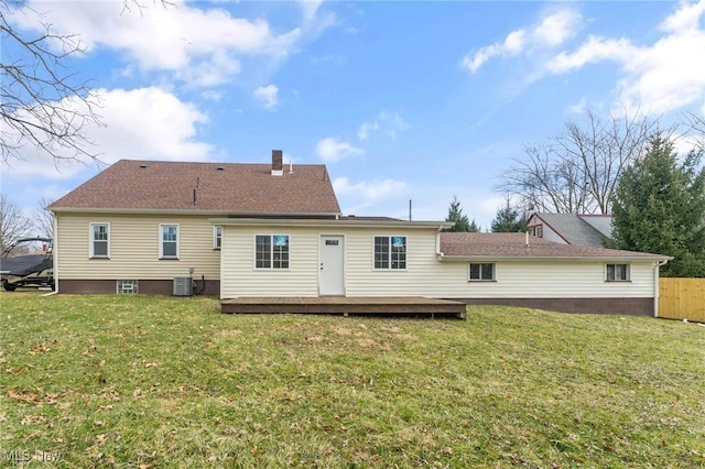 back of house with a wooden deck, a chimney, fence, and a yard