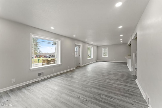 unfurnished living room with baseboards, wood finished floors, and recessed lighting