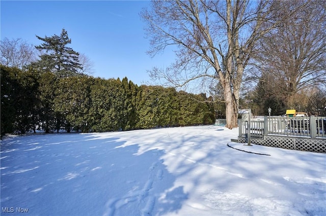 yard layered in snow featuring a wooden deck