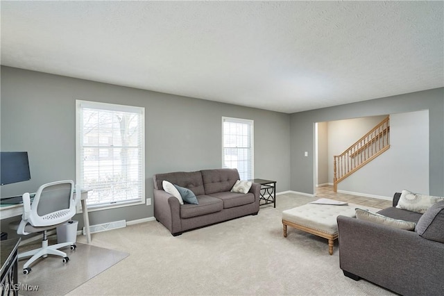 living area featuring carpet floors, plenty of natural light, stairway, and baseboards