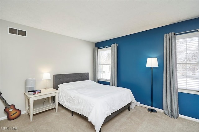 carpeted bedroom featuring baseboards and visible vents