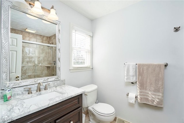 full bathroom with a stall shower, vanity, and toilet