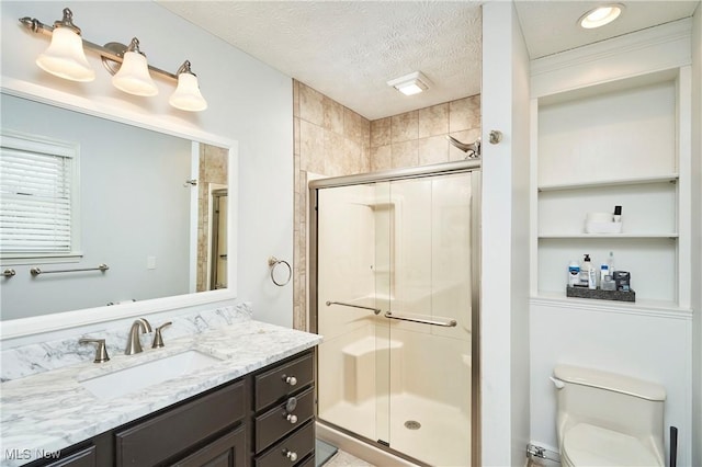 full bath featuring a textured ceiling, built in shelves, toilet, vanity, and a stall shower