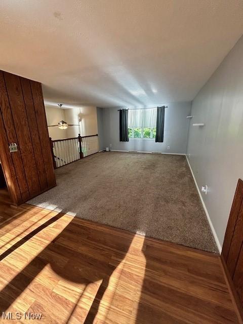 spare room featuring ceiling fan, baseboards, wood finished floors, and carpet flooring