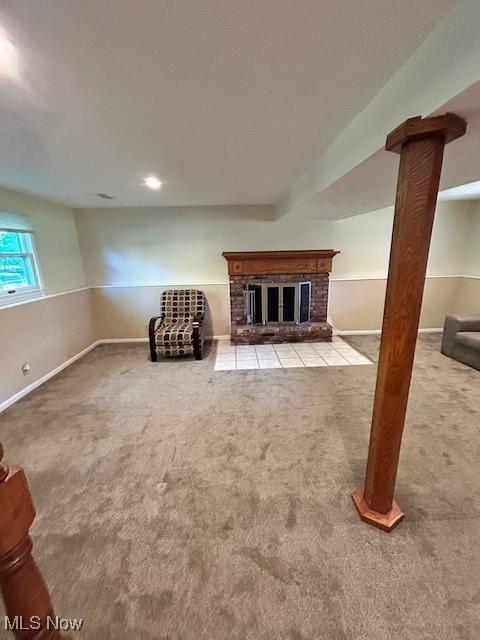 below grade area featuring carpet floors, a fireplace, and baseboards