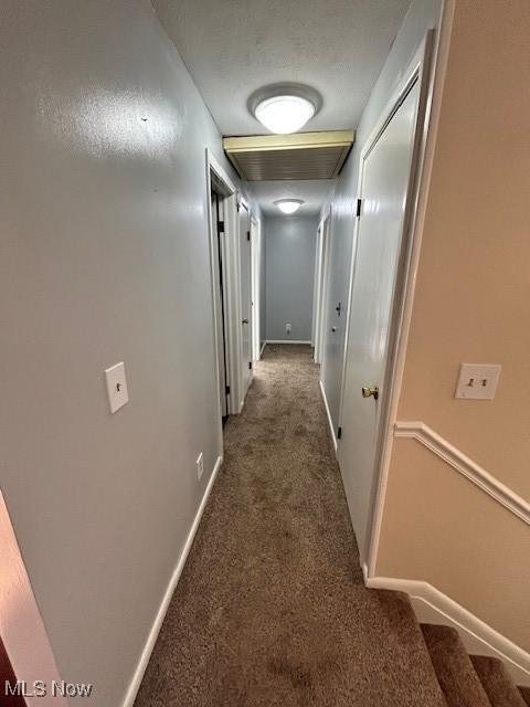 corridor with carpet floors and baseboards