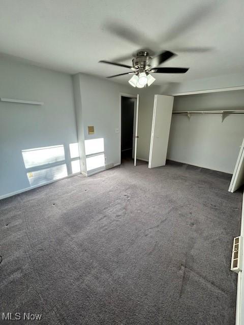 unfurnished bedroom featuring a ceiling fan, two closets, and carpet flooring