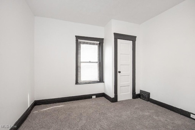 unfurnished room featuring carpet flooring, visible vents, and baseboards