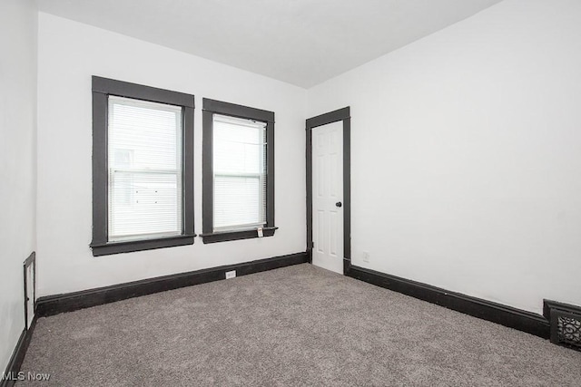 empty room featuring carpet flooring and baseboards