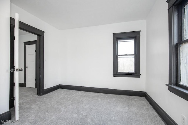 carpeted spare room featuring baseboards