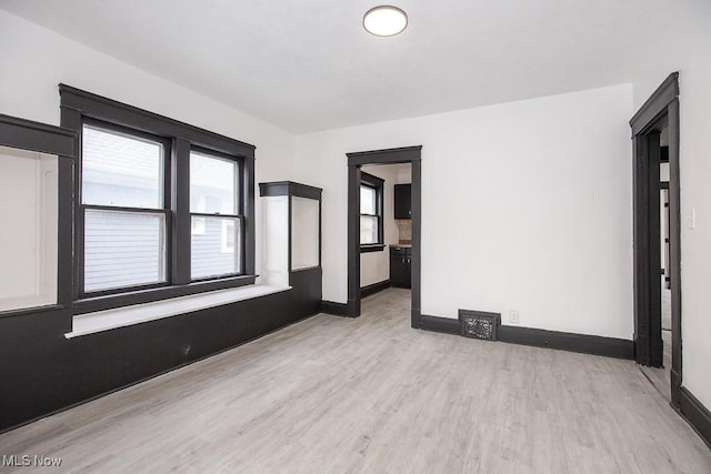 empty room featuring light wood-style flooring and baseboards