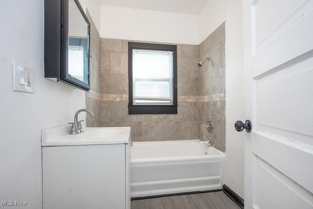 bathroom featuring  shower combination, vanity, and wood finished floors