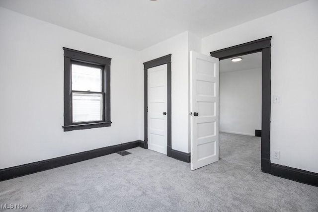 unfurnished bedroom featuring carpet and baseboards