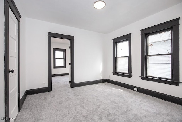 unfurnished room featuring carpet floors and baseboards