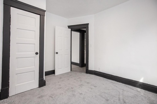 unfurnished bedroom featuring carpet and baseboards